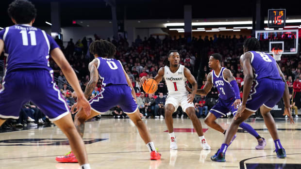 Cincinnati Bearcats guard Day Day Thomas (1) dribbles outside the 3-point line as the TCU Horned Frogs defend in the first half of a college basketball game between the TCU Horned Frogs and the Cincinnati Bearcats, Tuesday, Jan. 16, 2024, at Fifth Third Arena in Cincinnati.  